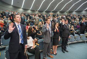 (Front row from left, standing) David D. Oberst, Barret R. Arthur, Deanna M. Cairo and Geoffrey E. Jacobs —all graduates of The John Marshall Law School —raise their right hand to be officially sworn-in as lawyers during the 1st District bar admission ceremony at the Thompson Center. With 691 attorneys becoming licensed throughout the state, the number of registered lawyers in Illinois climbed to 93,247. 