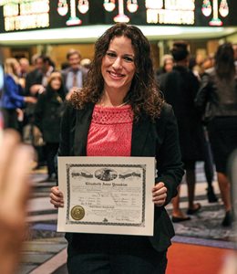 Elizabeth Youakim, a Loyola University Chicago School of Law graduate, poses with her law license after the bar admission ceremony at the Arie Crown Theater. 